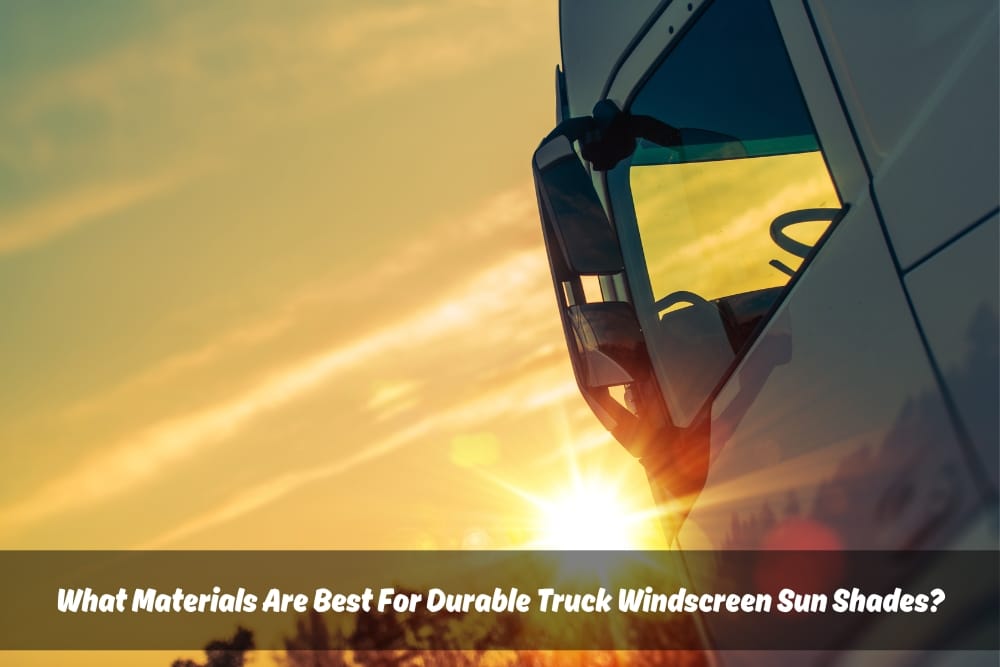 Close-up side view of a truck windshield reflecting the intense sunlight. White text on the windshield reads: "What materials are best for durable truck windscreen sun shades?