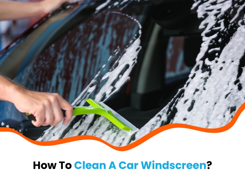 Person cleaning a soapy car windscreen with a squeegee. Text: 'How To Clean A Car Windscreen.