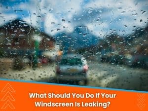 Raindrops on a leaking windscreen, obstructing the driver’s view in a wet, urban environment.