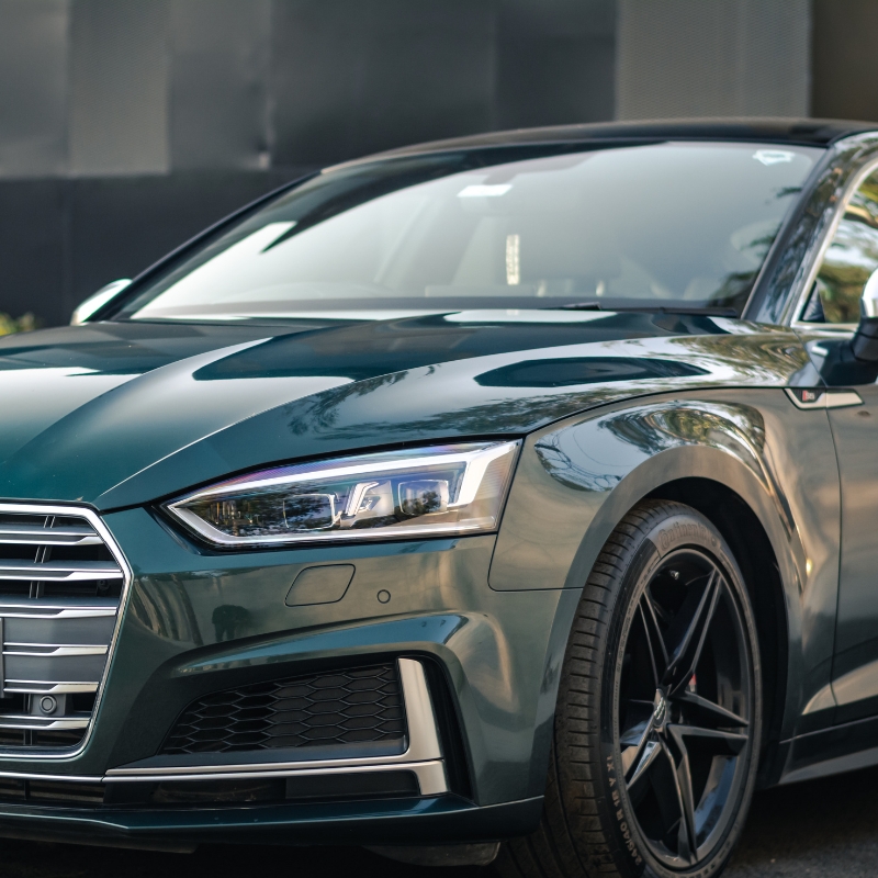 Audi windscreen replacement shown on a sleek green luxury car, highlighting a perfectly installed front windshield for safety.