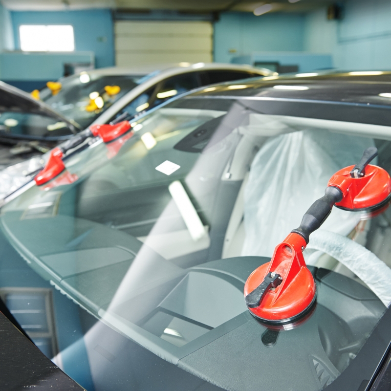 Hyundai windscreen replacement in progress with professional tools attached to the glass for secure installation at a workshop.