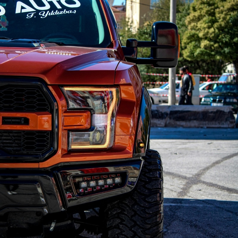 Close-up of a customised orange Ford Ranger windscreen replacement in a parking lot.